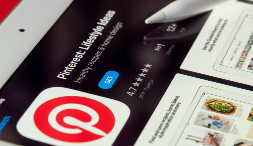 Ekran tabletu z widokiem strony aplikacji Pinterest w App Store – ocena 4,7 gwiazdki, ponad 261 tys. opinii, kategoria nr 1 w Lifestyle; aplikacja Pinterest do pobrania na iPada z rysikiem Apple Pencil w tle; polecana przez Weronikę Wolską z Akademii Projektowania.