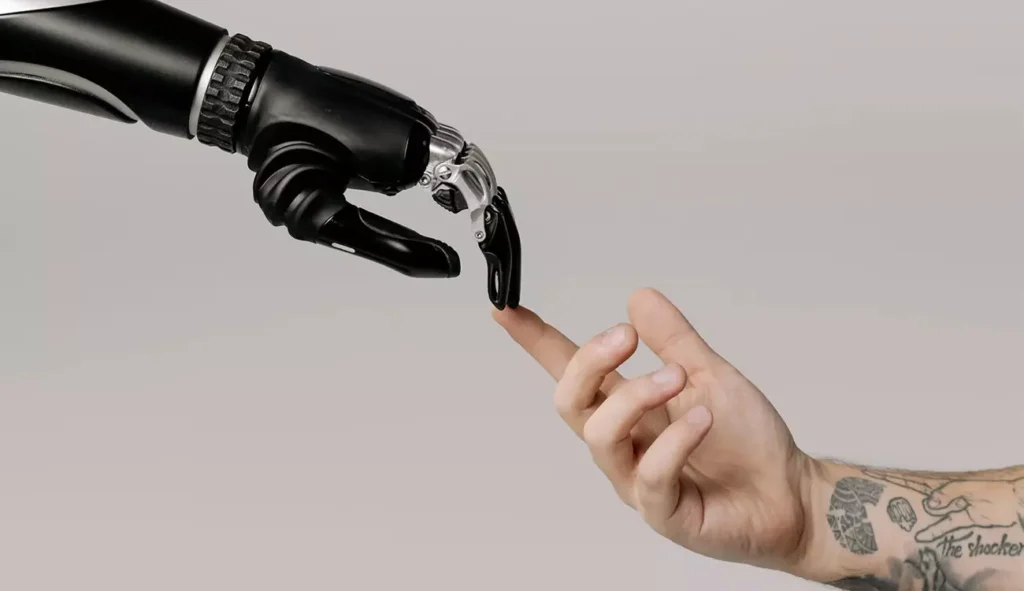 Ręka robota dotykająca ludzkiej dłoni – symbol współpracy człowieka ze sztuczną inteligencją w branży kreatywnej, omawianej przez Weronikę Wolską w Akademii Projektowania i Kursie Projektowania Graficznego